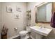 Stylish powder room with mosaic tiled walls, pedestal sink, and decorative shelving at 11522 Trona Ct, Parker, CO 80138