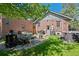 Brick home backyard with well-manicured lawn, patio seating, and lush landscaping at 1278 Dexter St, Denver, CO 80220