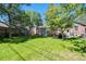 Expansive backyard featuring a well-kept lawn, mature trees, and a brick building with garden at 1278 Dexter St, Denver, CO 80220
