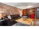 This basement living area showcases a decorative brick wall and comfortable seating at 1278 Dexter St, Denver, CO 80220