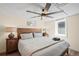 Bedroom with a rustic wood bed frame, ceiling fan, and natural light from two windows at 1278 Dexter St, Denver, CO 80220
