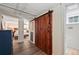 Spacious bedroom view through an open sliding barn door with hardwood floors and natural light at 1278 Dexter St, Denver, CO 80220