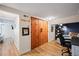 Hallway with a glimpse of an office space and large wood sliding closet doors at 1278 Dexter St, Denver, CO 80220