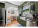 Inviting kitchen with a built-in dining nook, wooden countertops, stainless steel appliances, and stylish green cabinetry at 1278 Dexter St, Denver, CO 80220