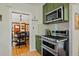 Well-equipped kitchen showing stainless steel oven and cooktop, stylish green cabinetry, and an open connection to the dining room at 1278 Dexter St, Denver, CO 80220