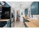 Updated kitchen featuring modern appliances, butcher block countertops, and blue cabinetry at 4429 Winona Ct, Denver, CO 80212