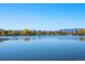 Scenic lake view with distant mountains, serene water, and lush trees at 4429 Winona Ct, Denver, CO 80212