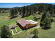 Aerial view showcasing the home's layout with a spacious yard, driveway, and lush surroundings at 1971 Kerr Gulch Rd, Evergreen, CO 80439