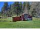 Exterior shot of a red barn on a property with a wide lawn at 1971 Kerr Gulch Rd, Evergreen, CO 80439