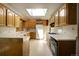 Bright kitchen with oak cabinets, white countertops, and a skylight offering natural light at 1971 Kerr Gulch Rd, Evergreen, CO 80439
