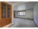 Spacious living room featuring neutral carpeting, a large window, and built-in shelving at 1971 Kerr Gulch Rd, Evergreen, CO 80439