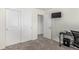 Cozy bedroom featuring sliding closet doors, carpeted floors, and a conveniently mounted TV on the wall at 803 N Bently St, Watkins, CO 80137