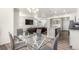 Open-concept floorplan, dining room with a glass-top table and open view to living room and kitchen at 803 N Bently St, Watkins, CO 80137