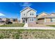 Attractive two-story home has light gray siding, stone accents, and a sidewalk at 803 N Bently St, Watkins, CO 80137