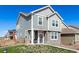Charming two-story home features stone accents, light gray siding and a well-manicured lawn at 803 N Bently St, Watkins, CO 80137