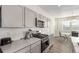 Kitchen boasts gray cabinets, stone countertops, stainless oven, and hardwood floors at 803 N Bently St, Watkins, CO 80137