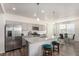 Kitchen with stainless appliances, gray cabinets, and kitchen island with attached dining area at 803 N Bently St, Watkins, CO 80137