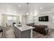 Open living area with kitchen island, stainless sink, hardwood flooring and comfortable leather couch at 803 N Bently St, Watkins, CO 80137