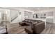 Open-concept living room and kitchen with hardwood floors, modern gray cabinets and stainless appliances at 803 N Bently St, Watkins, CO 80137