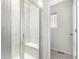 Modern shower featuring stylish vertical tiling, glass enclosure, built-in bench for comfort and convenience at 803 N Bently St, Watkins, CO 80137