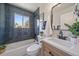 Modern bathroom featuring dark blue tiled walls and a white vanity with sleek fixtures at 3200 N Elizabeth St, Denver, CO 80205