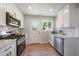 Updated kitchen with stainless steel appliances, white cabinets, and an eat-in dining area at 3200 N Elizabeth St, Denver, CO 80205