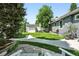 Green backyard with well-kept lawn, stone walkway, garden shed, and mature trees at 1451 S Columbine St, Denver, CO 80210