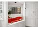 Bright bathroom boasts a red soaking tub with a glass block window and stylish white paneled closet doors at 1451 S Columbine St, Denver, CO 80210