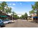 Street view of Historic South Gaylord with shops, trees and parked cars under a bright blue sky at 1451 S Columbine St, Denver, CO 80210