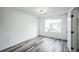 Bright bedroom featuring new gray flooring, white walls and trim, and a large window at 956 S Peoria St, Aurora, CO 80012