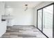Open living room featuring new flooring, modern lighting, and glass patio door to balcony at 956 S Peoria St, Aurora, CO 80012