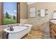 Soaking tub by a window providing nice outdoor views and a double sink vanity add elegance to this well-designed bathroom at 3021 N Lakeridge Trl, Boulder, CO 80302