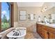 Relaxing bathroom with a soaking tub by the window, double sink vanity, and earth toned decor at 3021 N Lakeridge Trl, Boulder, CO 80302