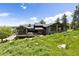 Two-story home with large windows, a covered deck, and mature trees at 3021 N Lakeridge Trl, Boulder, CO 80302