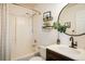 Renovated bathroom features a sleek vanity, round mirror, and shower with modern fixtures at 3674 Dexter St, Denver, CO 80207