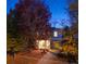 Charming two-story home with a well-maintained front yard and colorful trees at dusk at 3674 Dexter St, Denver, CO 80207