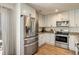 Well-lit kitchen features stainless steel appliances, granite countertops, and wood-style floors at 3674 Dexter St, Denver, CO 80207