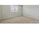 An airy bedroom with neutral carpeting and a large window allowing for plenty of natural light at 401 W Prestwick Way, Castle Rock, CO 80104