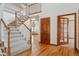 Inviting foyer with hardwood floors, staircase, and wood trim at 401 W Prestwick Way, Castle Rock, CO 80104