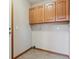 This practical laundry room has neutral walls, tile floors, and overhead storage at 401 W Prestwick Way, Castle Rock, CO 80104