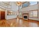 Open-concept living room with fireplace, hardwood floors, and soaring ceilings at 401 W Prestwick Way, Castle Rock, CO 80104