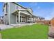 Spacious backyard with lush green lawn and covered patio, perfect for entertaining at 18077 E 99Th Ave, Commerce City, CO 80022