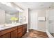 Well-lit bathroom with double vanity, wood cabinets, updated fixtures, and walk-in shower at 18077 E 99Th Ave, Commerce City, CO 80022