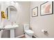 Charming powder room with pedestal sink, round mirror, modern fixtures, and decorative wall art at 18077 E 99Th Ave, Commerce City, CO 80022