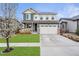 Charming two-story home featuring a well-manicured lawn and attached two-car garage at 18077 E 99Th Ave, Commerce City, CO 80022