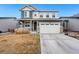 Inviting two-story home with a well-maintained lawn, a two-car garage, and charming architectural details at 18077 E 99Th Ave, Commerce City, CO 80022