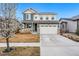 Charming two-story home featuring a manicured lawn, a two-car garage, and a welcoming front porch at 18077 E 99Th Ave, Commerce City, CO 80022