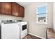 Well-lit laundry room featuring modern washer and dryer units and ample storage space at 18077 E 99Th Ave, Commerce City, CO 80022
