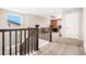 Upstairs loft with a dark wood staircase and a light filled office area at 18077 E 99Th Ave, Commerce City, CO 80022
