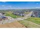 Broad aerial view of a community showcasing homes, landscaped green spaces, and roads, with grazing cattle in a field at 8517 Eckley St, Littleton, CO 80125